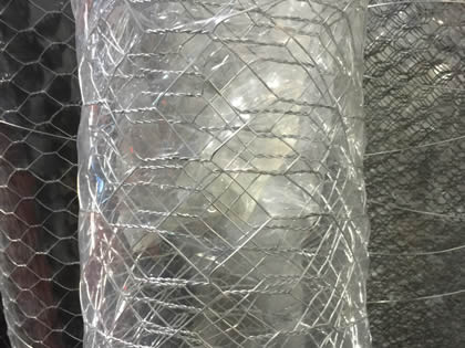 A roll of grey PVC coated hexagonal wire mesh with thick plastic film wrapped.