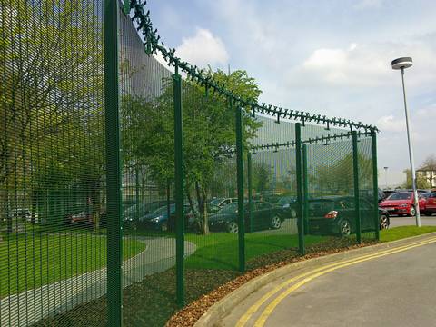 Many cars are parking in the park with 358 high security fence.