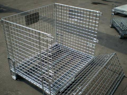 A silver wire mesh container with full dro gate open on ground.