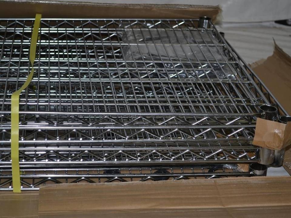 Many sheets of stainless steel welded wire mesh shelves are packed with baling strip and placed on carton.