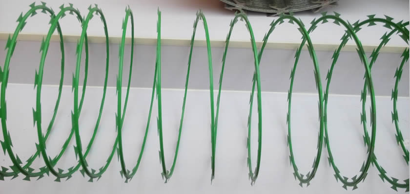 A concertina wire coil in green PVC painted on the floor.