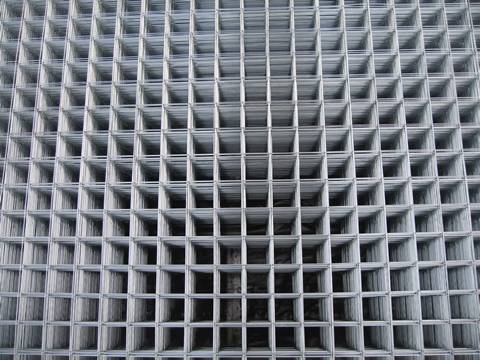 Many sheets of galvanized welded mesh panel with square holes.
