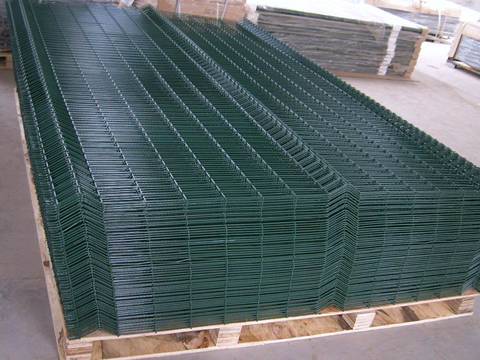 Many sheets of PVC coated dark green welded mesh panel are placed on wooden pallet.