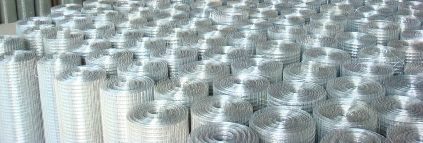 White zinc welded wire mesh rolls in warehouse.