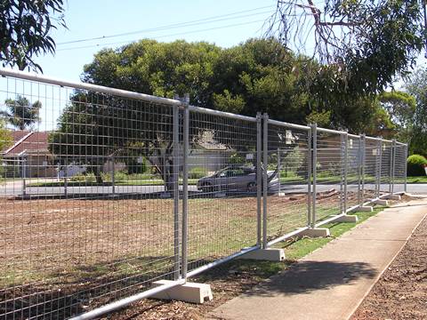 A car is in the park that has Australia portable fence.