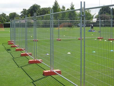 A people is playing in the playground that has Australia portable fence.