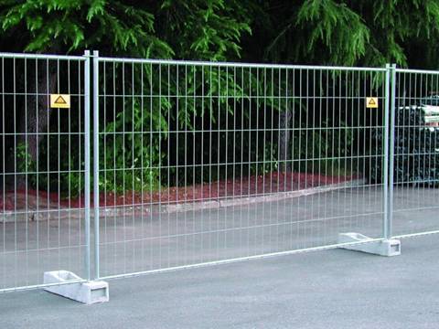 The Australia portable fence is installed in the street behind a park.