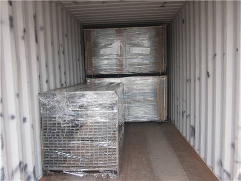 Many square posts are wrapped with plastic film and placed on the metal pallet.