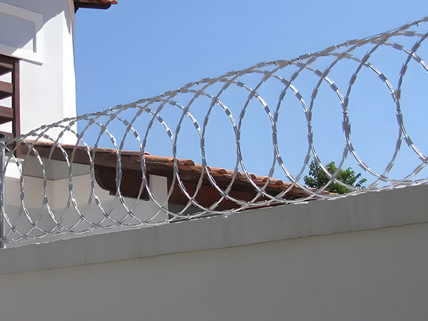 Flat wrap razor wire installed on top of the wall.