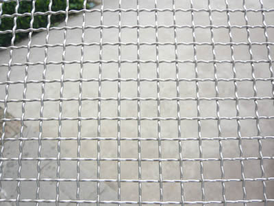 A piece of galvanized crimped wire mesh with square holes.