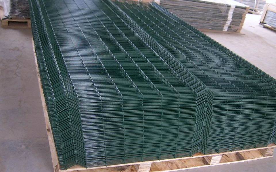 Many sheets of PVC coated dark green welded mesh panel are placed on wooden pallet.