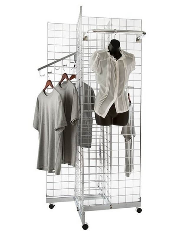A 4-way gridwall panel on the ground and several clothes hanging on it.