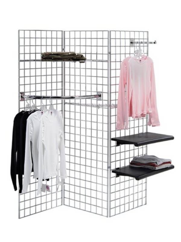 A three-piece grid wall on the ground with several clothes hanging on it.