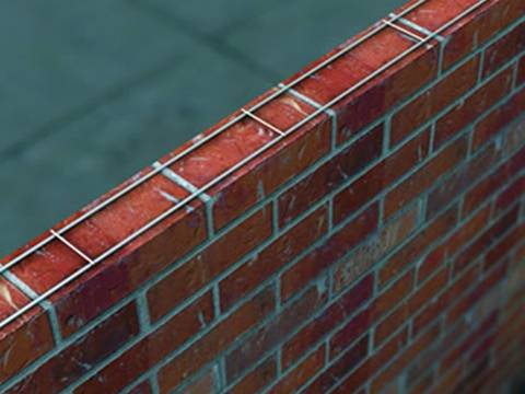 A piece of ladder mesh reinforcement is on the top of the wall.