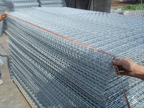 A stack of uninstalled gabion mesh and a sheet mesh is being measured.