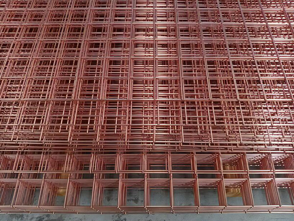 Lots of mild steel copper mesh welded mesh panels packed together on the ground