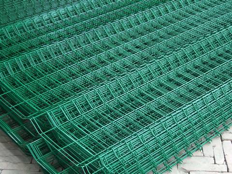 Many sheets of PVC coated welded wire mesh fence are placed together.