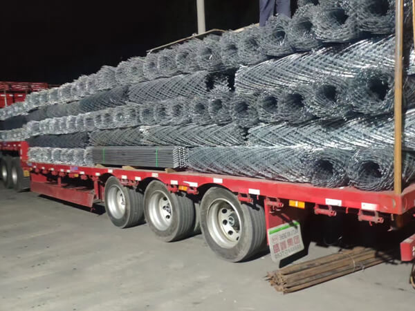 Several razor mesh fence rolls are neatly arranged in the truck