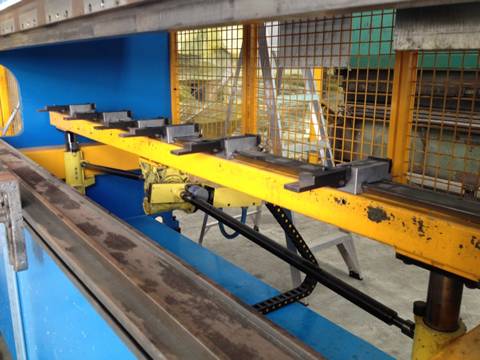 Yellow safety machine guard on the one side of CNC bending machine.