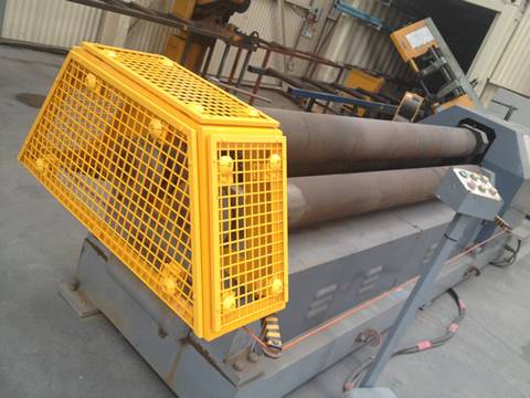Yellow safety machine guard is wrapping the exposed end of three pipelines.