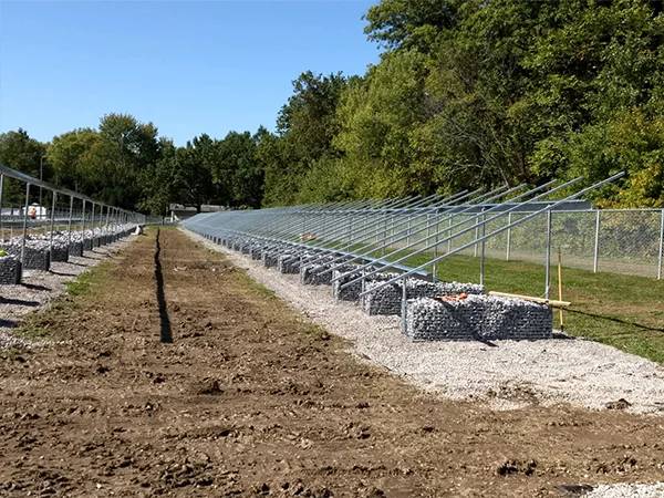 Base for solar panels fixed with gabion mesh and gravel on pavement