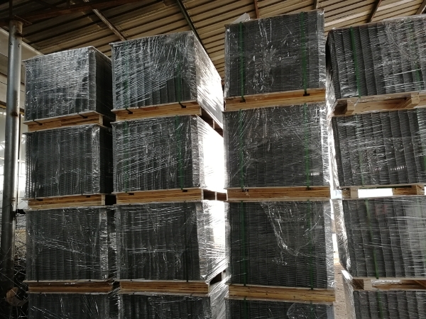 Several pallets of underfloor heating reinforcing meshes are piled in the warehouse.