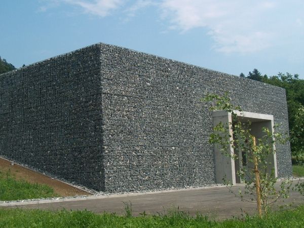 A welded gabion wall is built in the countryside.