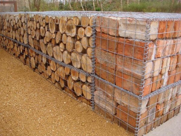 Welded gabion retaining wall filled with woods and bricks