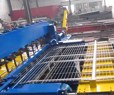 A blue welded wire mesh machine is producing the welded wire mesh panel.