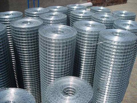 Several rolls of galvanized welded wire mesh rolls on the ground.