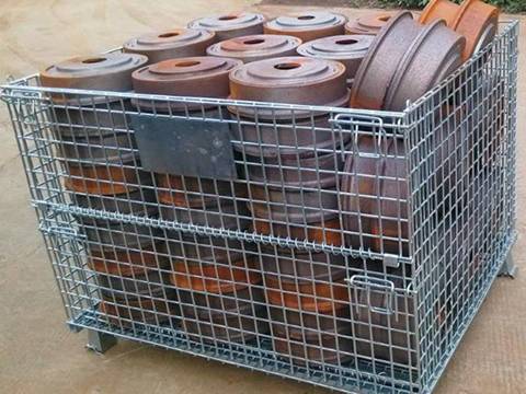 A wire mesh container is filled with parts.