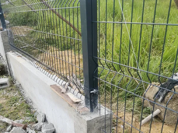 Wire mesh fence installed on concrete base with metal posts.
